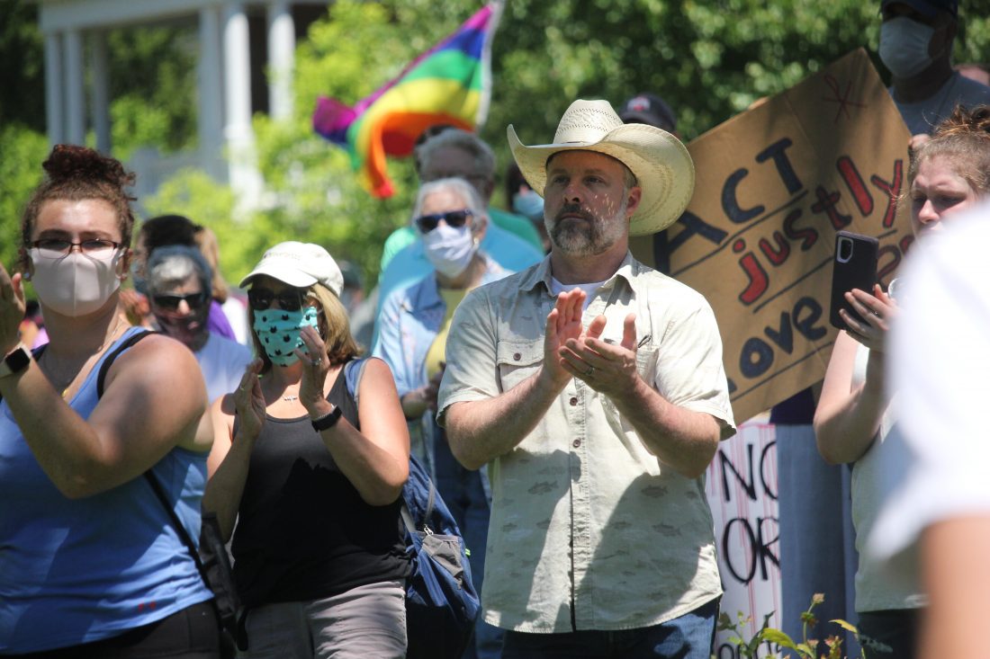 Bill Gossett claps during a speech on Sunday in East Muskingum Park calling out social injustice and racial profiling.